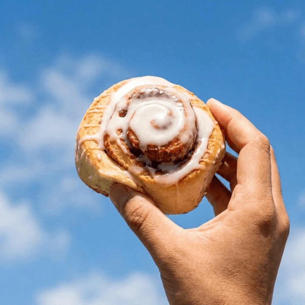 a tandoco protein cinnamon roll floating on a cloud