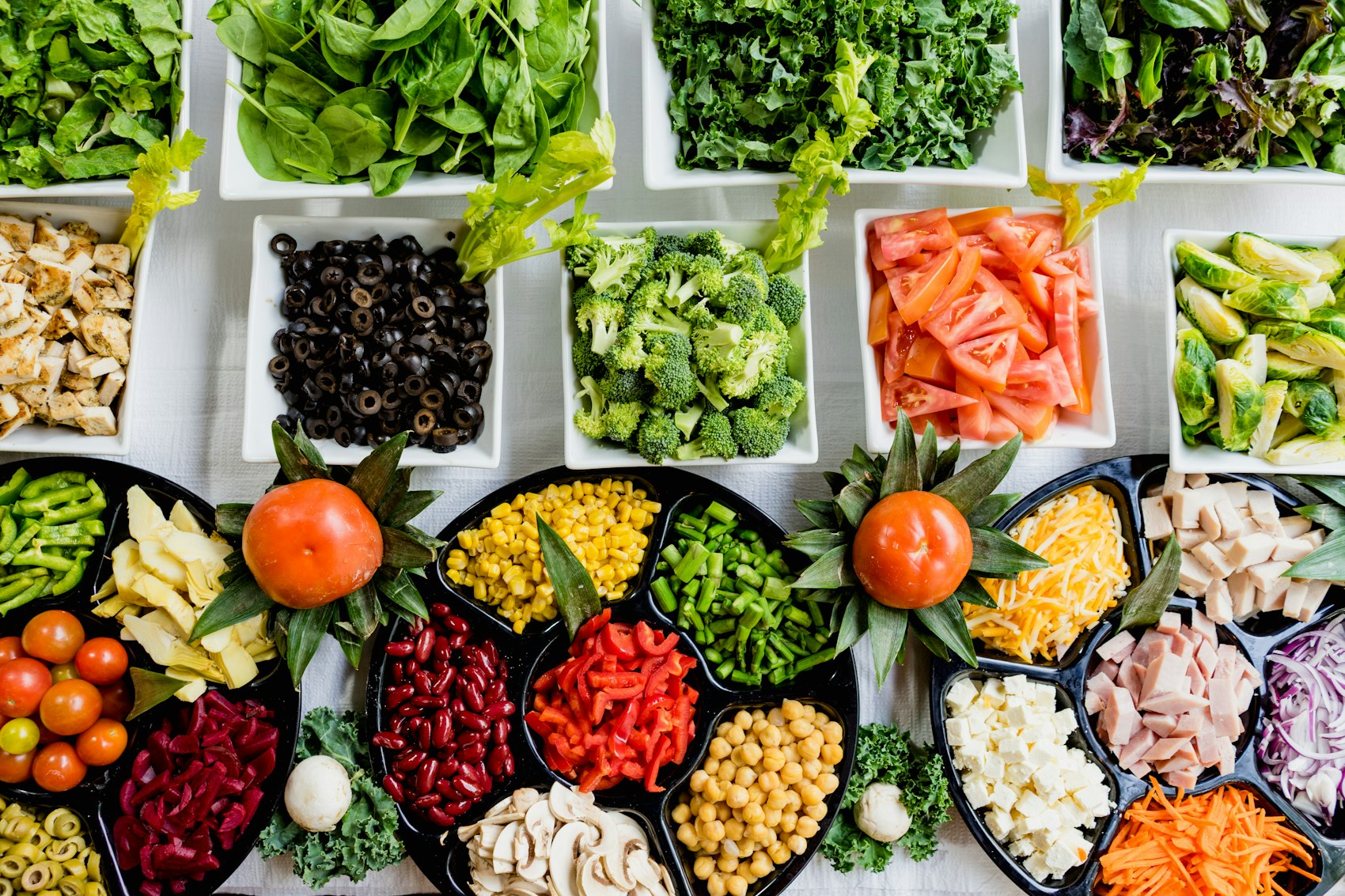 hands passing fresh dishes across a shared community table
