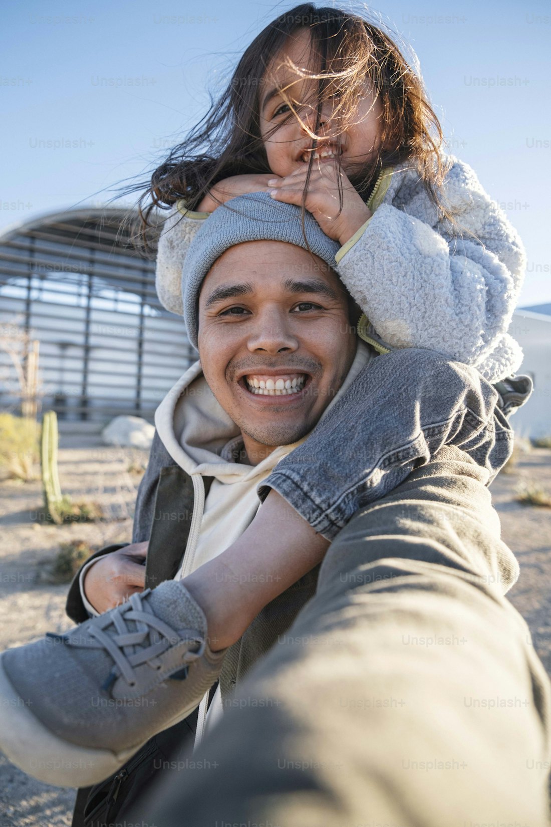 a dad giving his daughter a piggyback ride