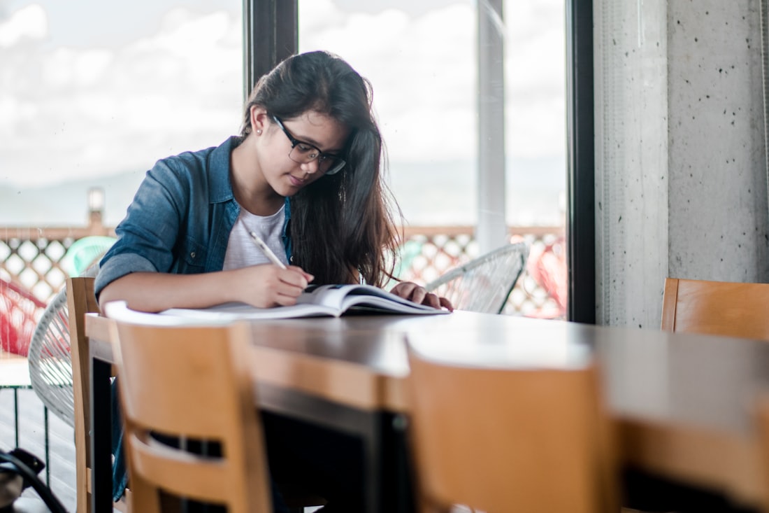 a student studying over books in a cafe